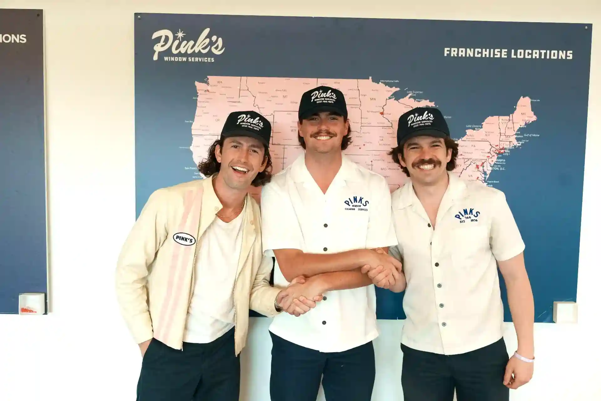 Launch day, Pink's Window Services franchisees celebrating in front of the franchise locations map