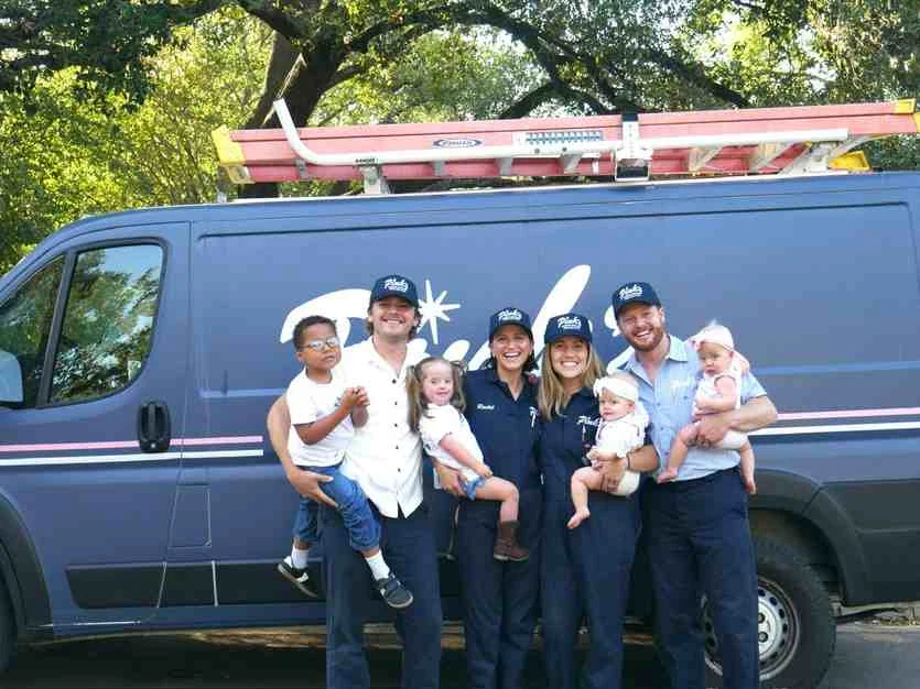 Two Pink's Window Services owner families with their kids in front of a Pink's van, representing generational wealth